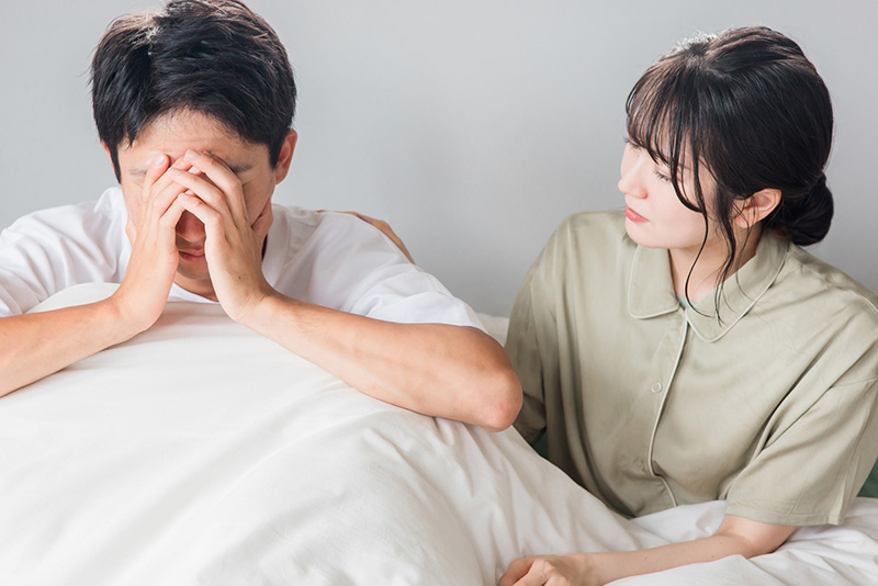 悩む男性とそれを励ます女性